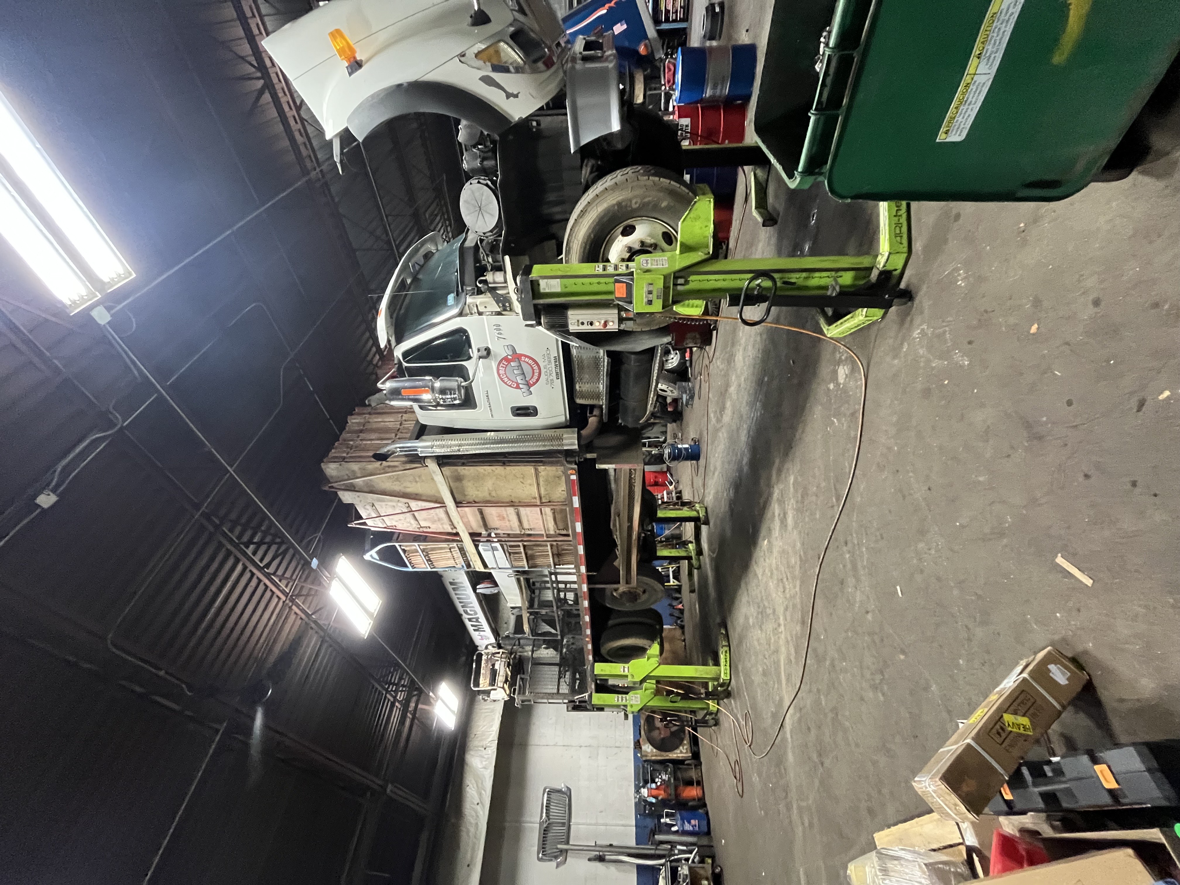 Commercial truck on hydraulic lifts for engine repair at R J Hallisey Truck Repair Wakefield Massachusetts