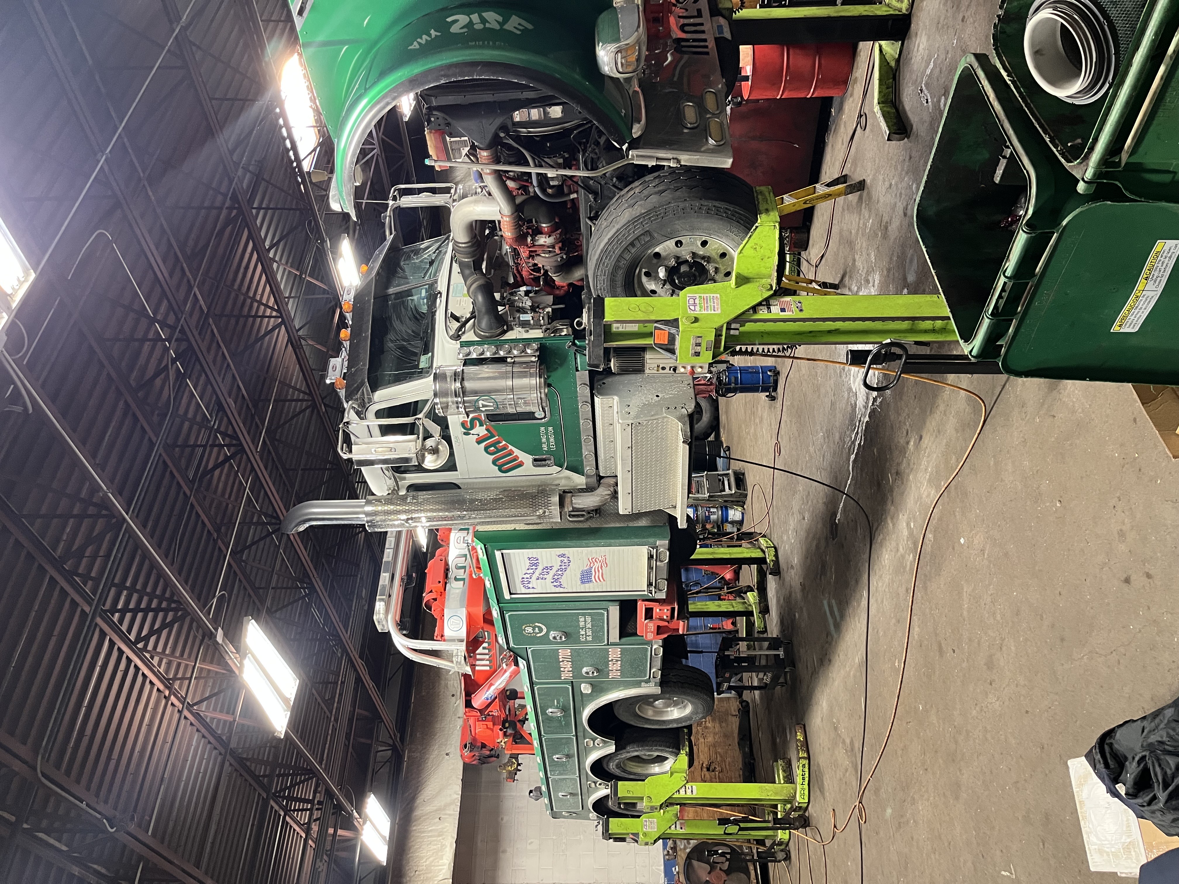 Heavy-duty tow truck engine repair on mobile column lifts at R J Hallisey Truck Repair