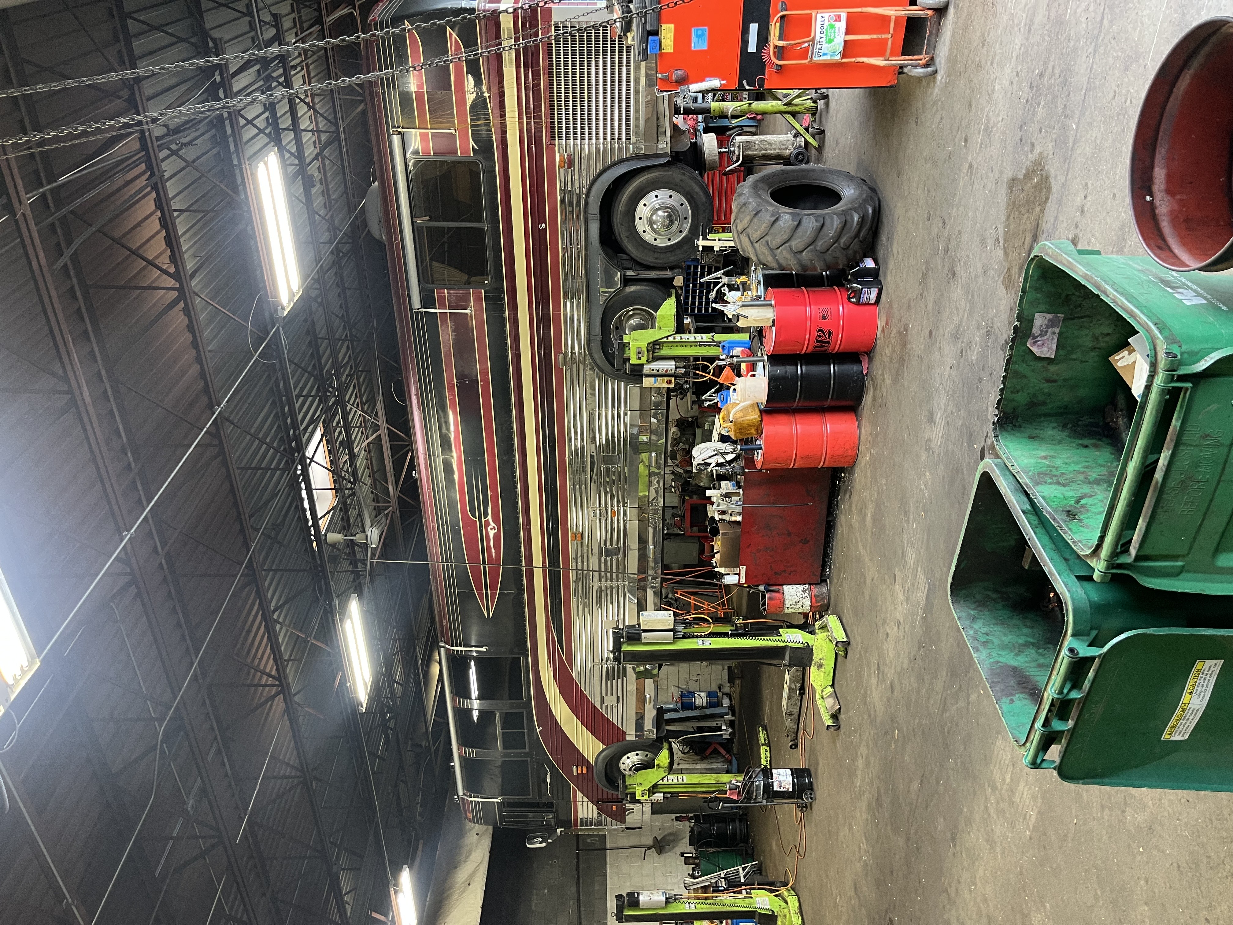 Tour bus elevated on heavy-duty lifts for undercarriage repair at Wakefield truck shop